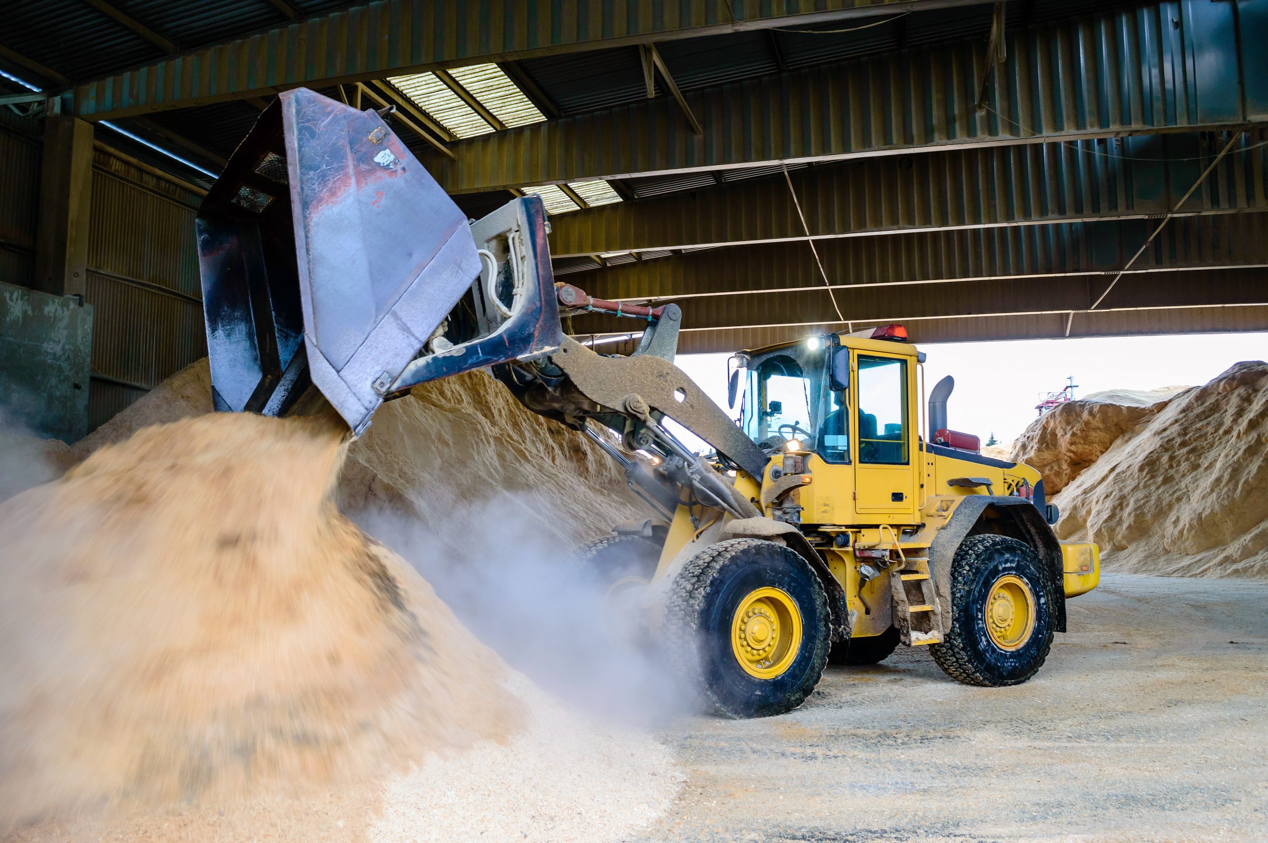 Front,Loader,Emptying,Wood,Chips,In,Pile,For,Use,In